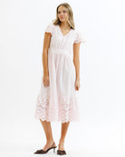Woman wearing a pink lace dress on a white background