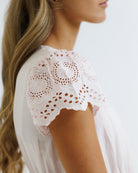 Close-up of a pink lace-trimmed top on a blurred background