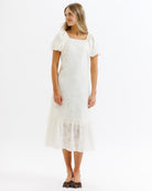 Woman wearing a white lace dress on a white background