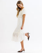 Woman wearing a white dress with a plain background