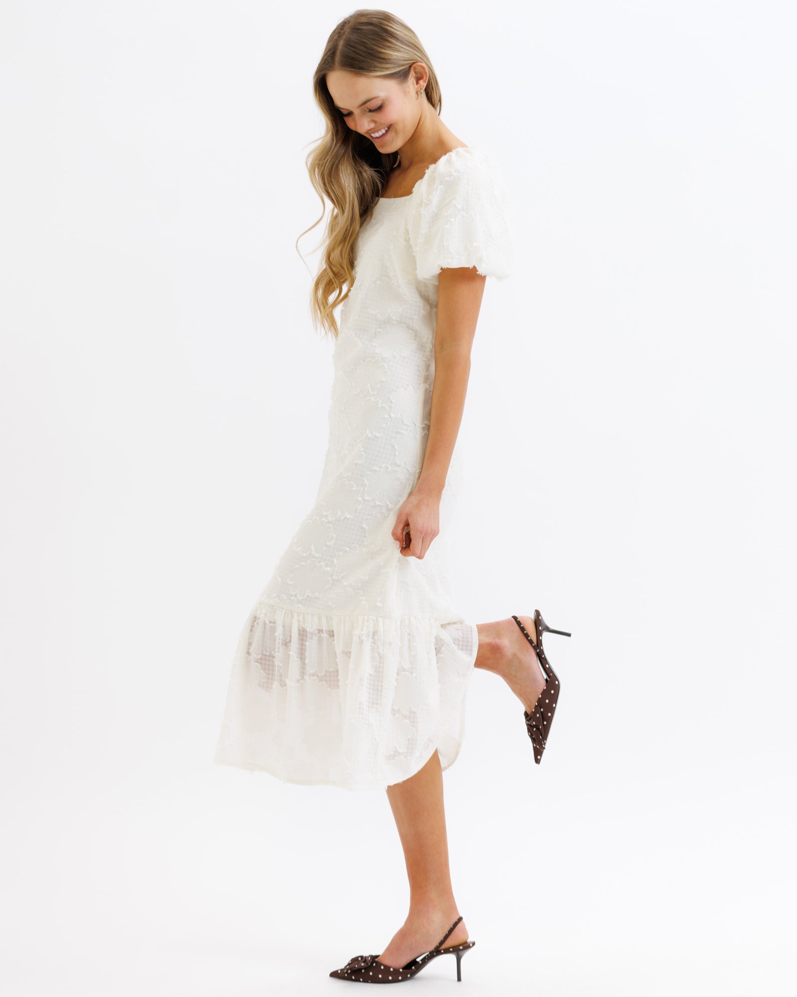 Woman wearing a white dress with a plain background