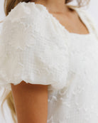 Close-up of a textured white garment with a blurred background