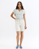 Woman wearing a striped shirt and white shorts on a white background