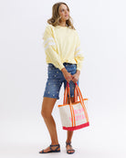 Woman holding a tote bag with text on a white background