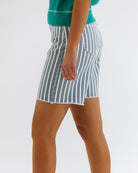 Person wearing a blue and white striped skirt on a plain background