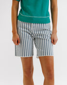 Person wearing blue and white striped shorts on a plain background