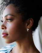 Close-up of a woman wearing gold hoop earrings with a blurred background