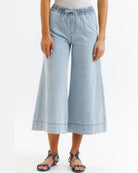 Light blue denim culottes worn by a person on a white background