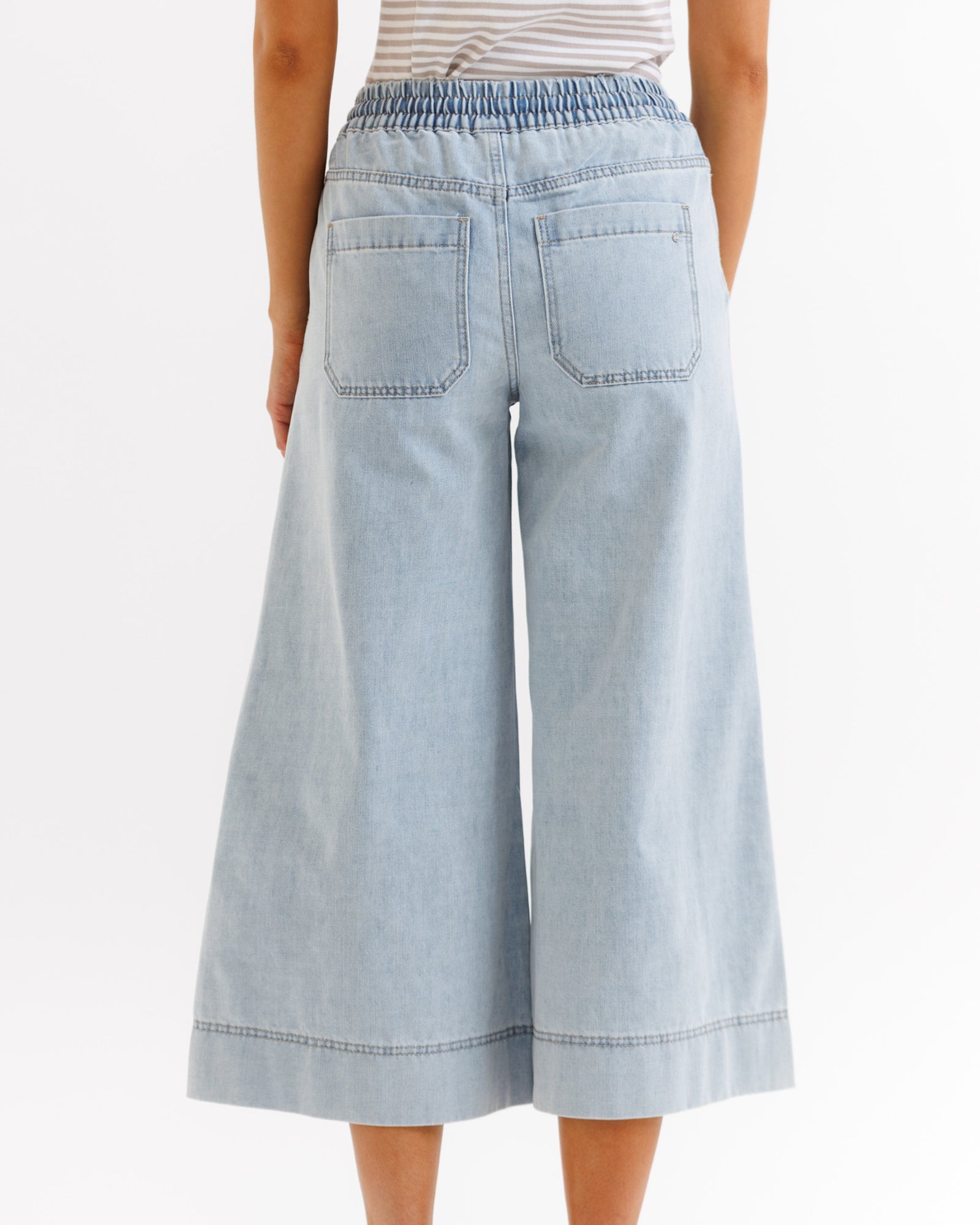 Light blue denim culottes worn by a person on a white background