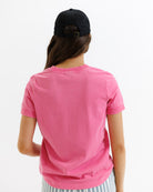 Person wearing a pink t-shirt and black cap from behind on a white background