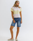 Woman wearing a striped shirt and denim shorts on a white background