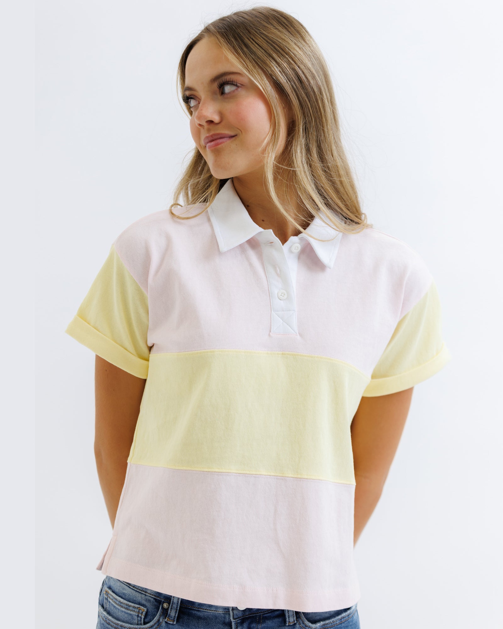 Woman wearing a white and yellow striped shirt against a white background