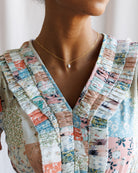 Person wearing a colorful patchwork jacket with a blurred background