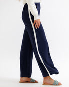Navy pants with a white stripe worn by a person on a white background