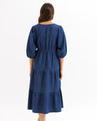 Woman wearing a blue dress with puffed sleeves on a white background