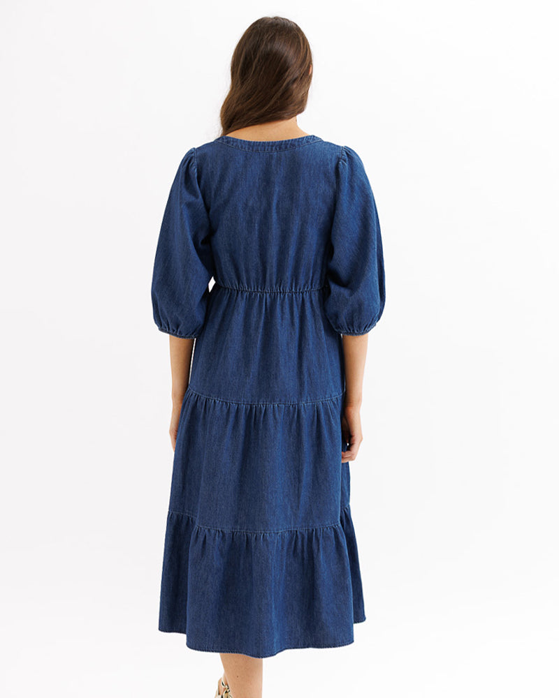 Woman wearing a blue dress with puffed sleeves on a white background