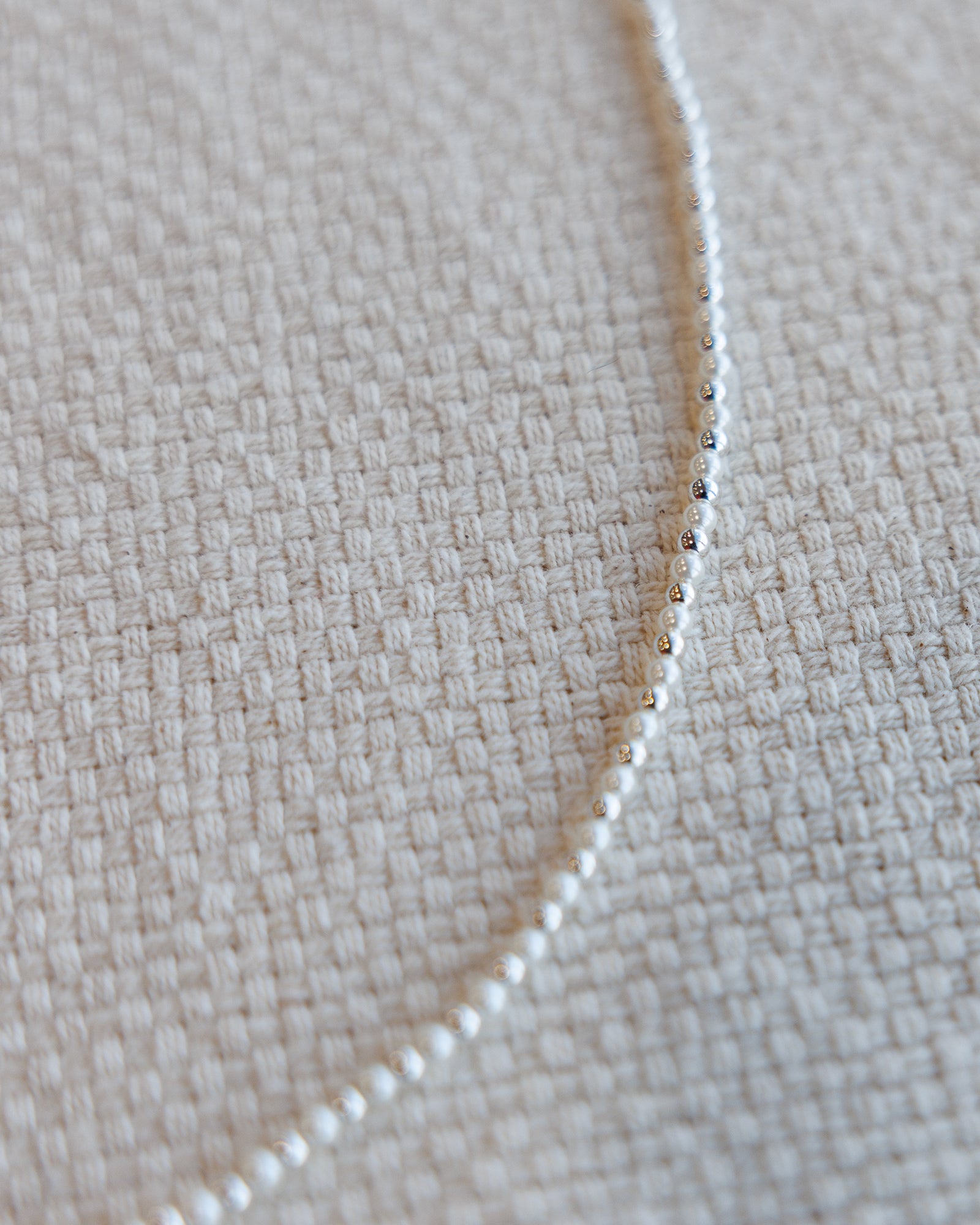 Close-up of a pearl and silver beaded necklace