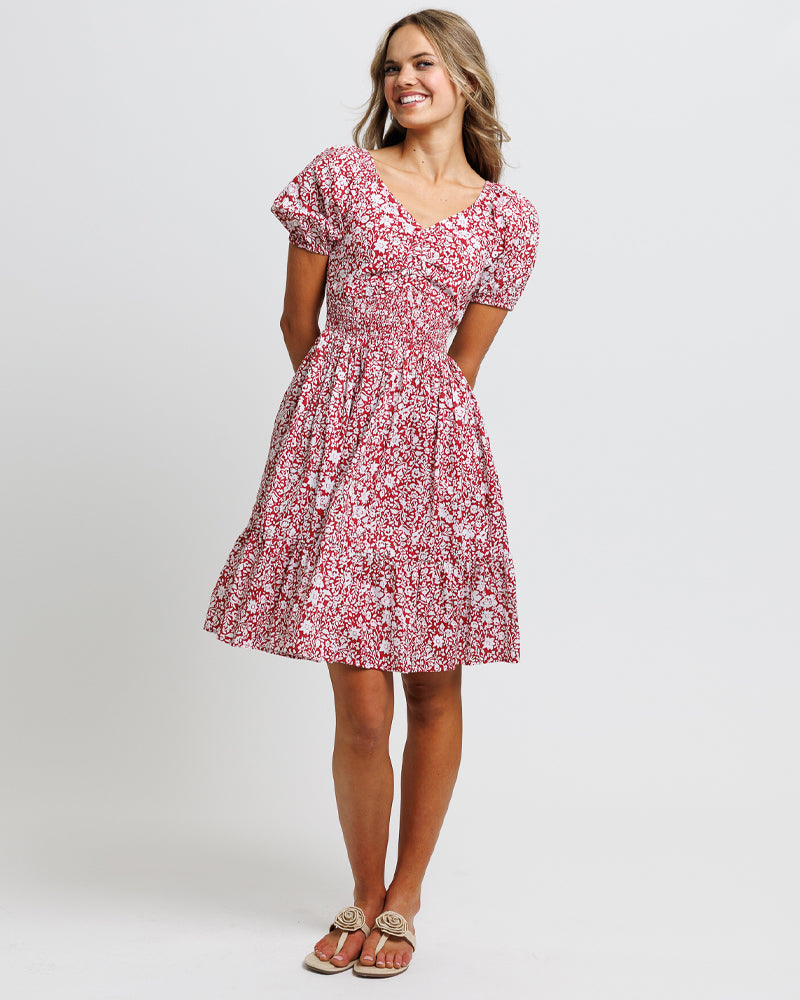 Model wearing a red with white floral print short sleeve sweetheart neckline knee length dress