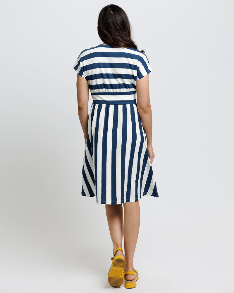 Model wearing a navy and blue striped short sleeve midi length knit dress