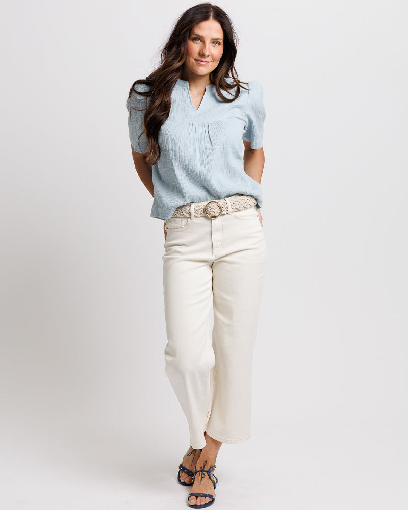 Model wearing a pair of white cropped denim jeans.