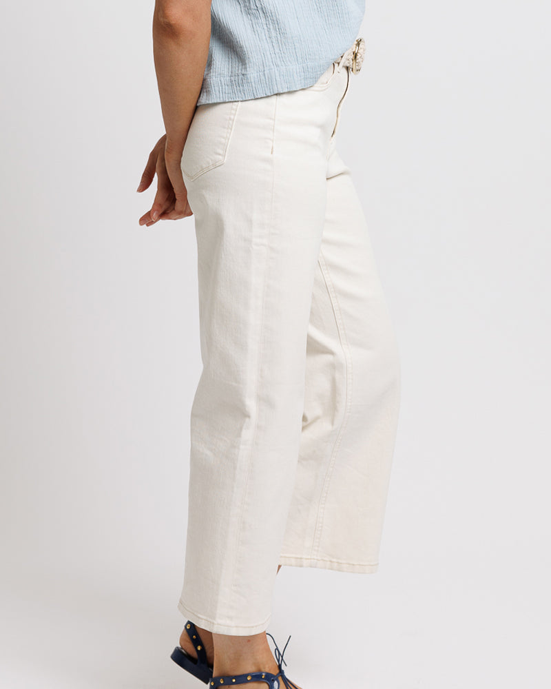 Model wearing a pair of white cropped denim jeans.
