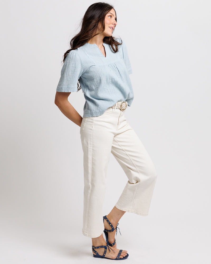 Model wearing a pair of white cropped denim jeans.