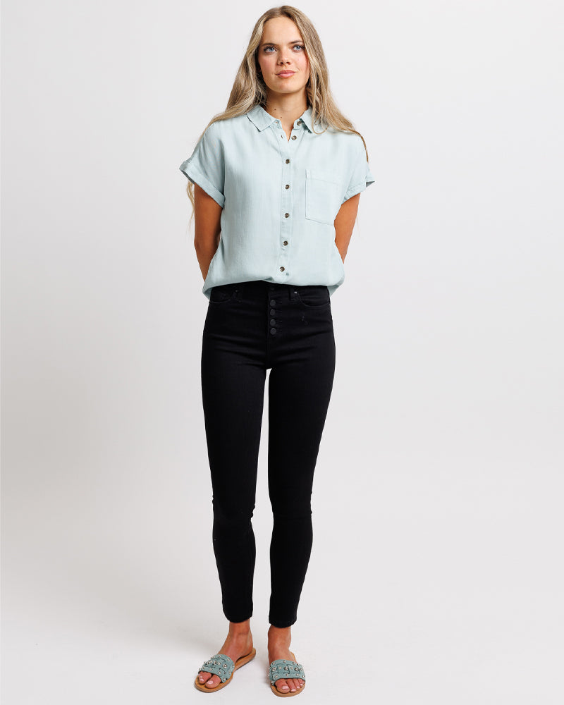Woman in a high-waisted, black, denim pant