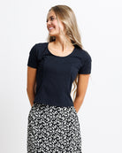 Model wearing a black short sleeve scoop neck tee