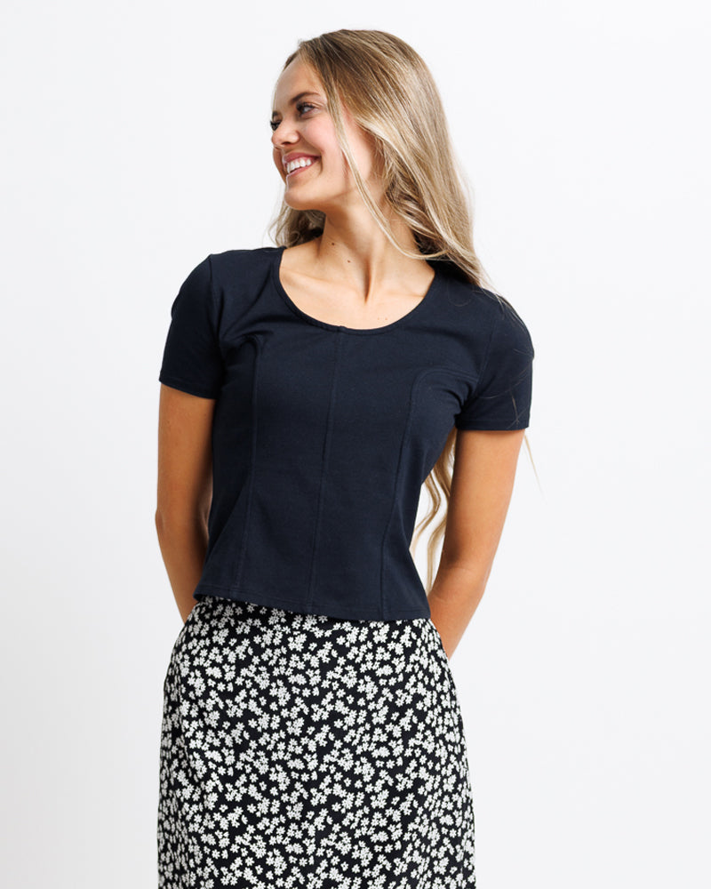 Model wearing a black short sleeve scoop neck tee