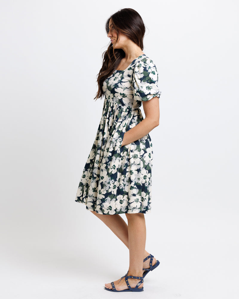 Model wearing a navy, green and white floral print short sleeve square neck knee length dress