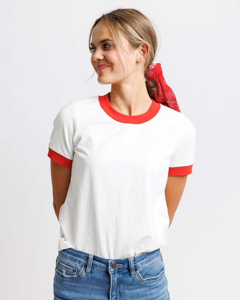 Model wearing a white with red edging short sleeve, crew neck t-shirt