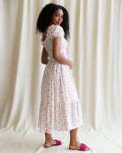 Woman wearing a floral dress against a plain background