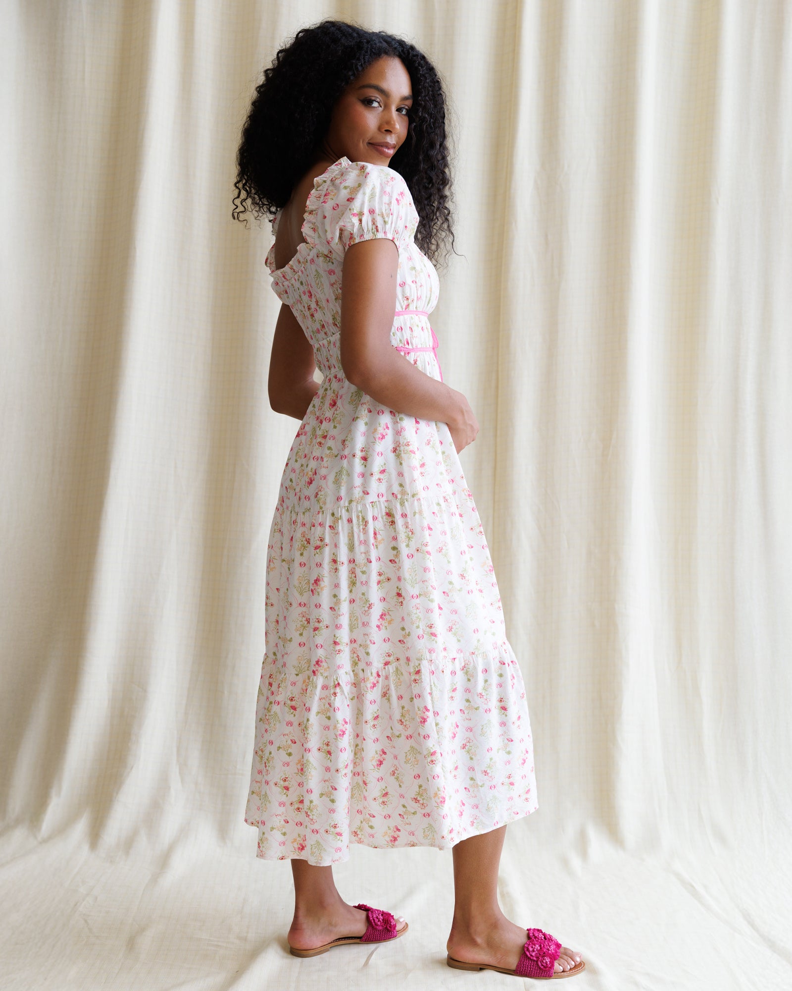 Woman wearing a floral dress against a plain background