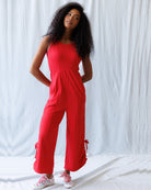 Woman wearing a red jumpsuit against a white background