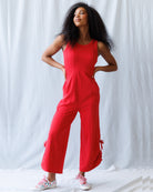Woman wearing a red jumpsuit against a white background