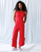 Woman wearing a red jumpsuit against a white background