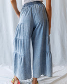 Light blue tiered pants worn by a person against a white background