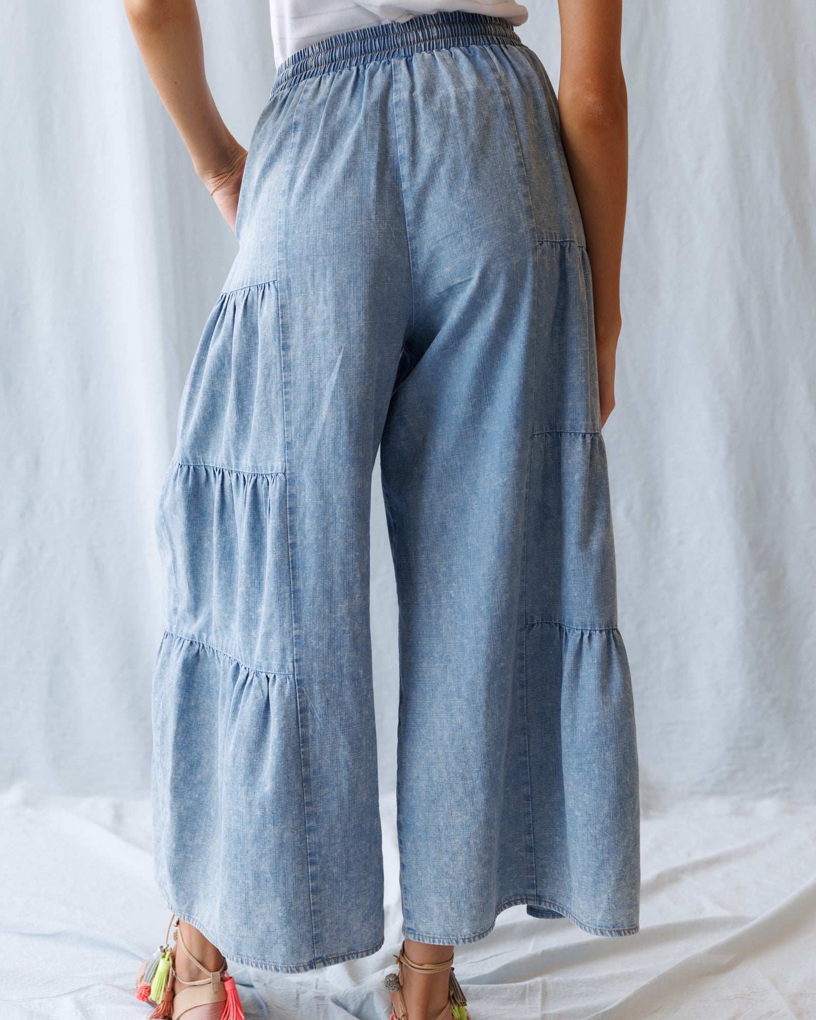 Light blue tiered pants worn by a person against a white background