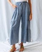 Person wearing light blue wide-leg pants with a white background