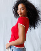 Woman wearing a red sweater with a white background