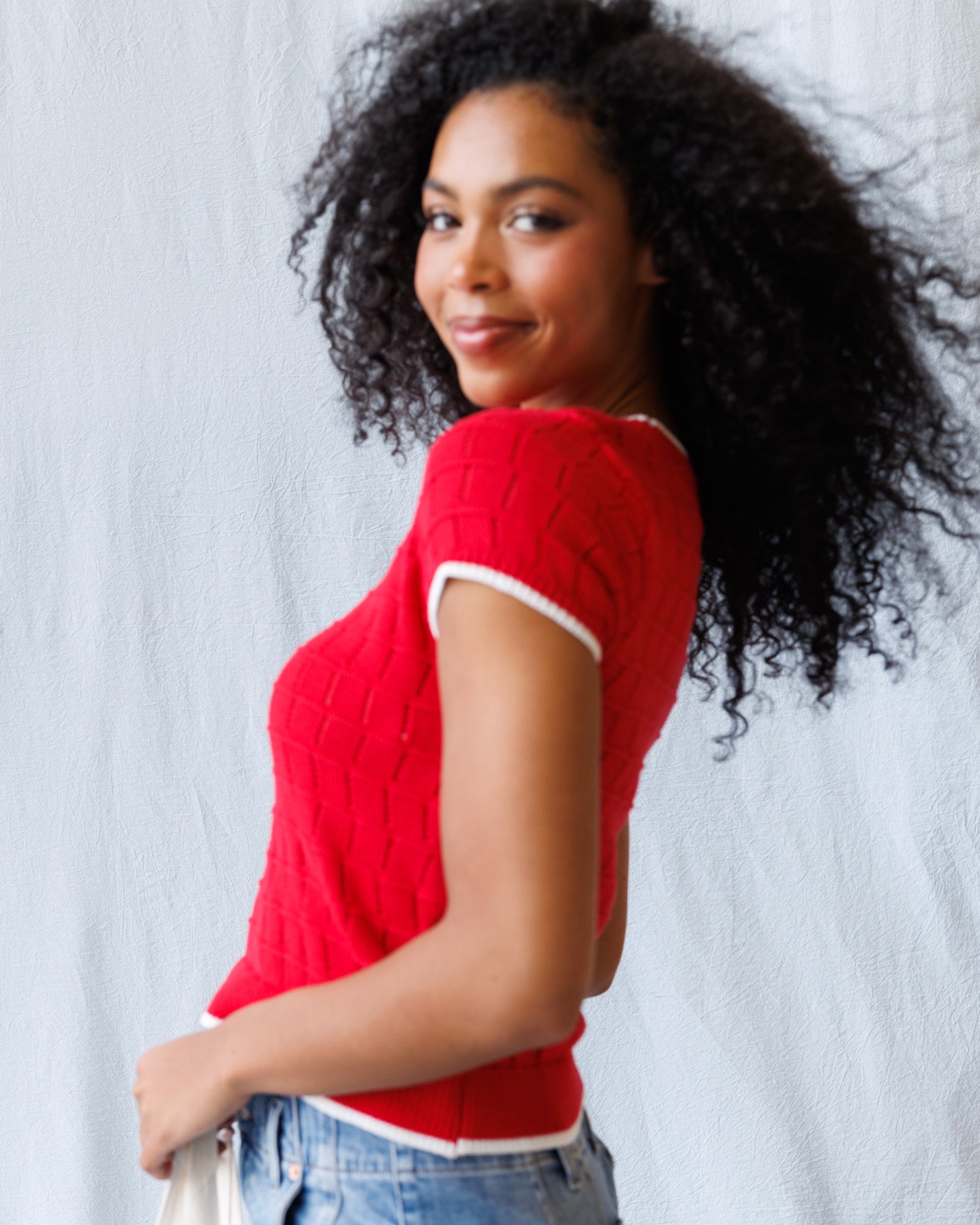 Woman wearing a red sweater with a white background