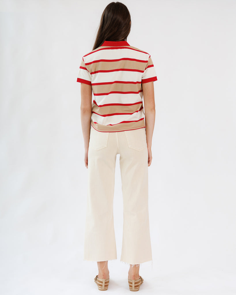 Person wearing a red and white striped shirt with beige pants on a white background
