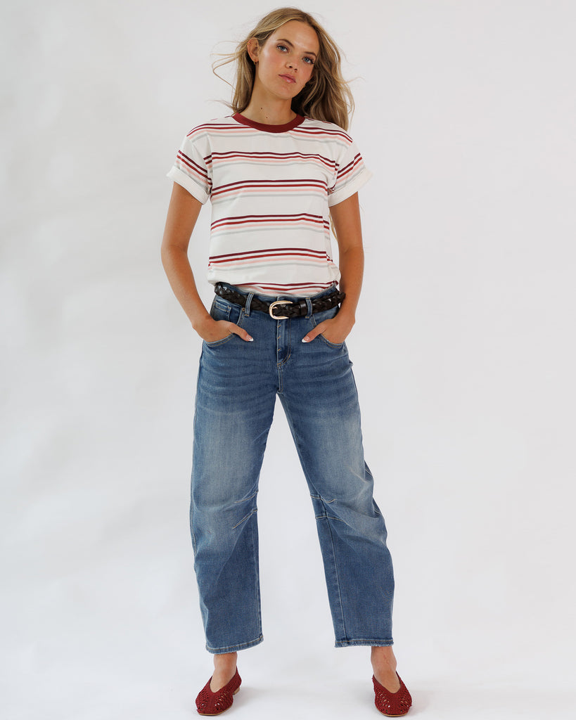 Woman wearing a striped shirt and jeans on a white background