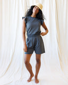 Woman wearing a polka dot outfit against a white curtain background