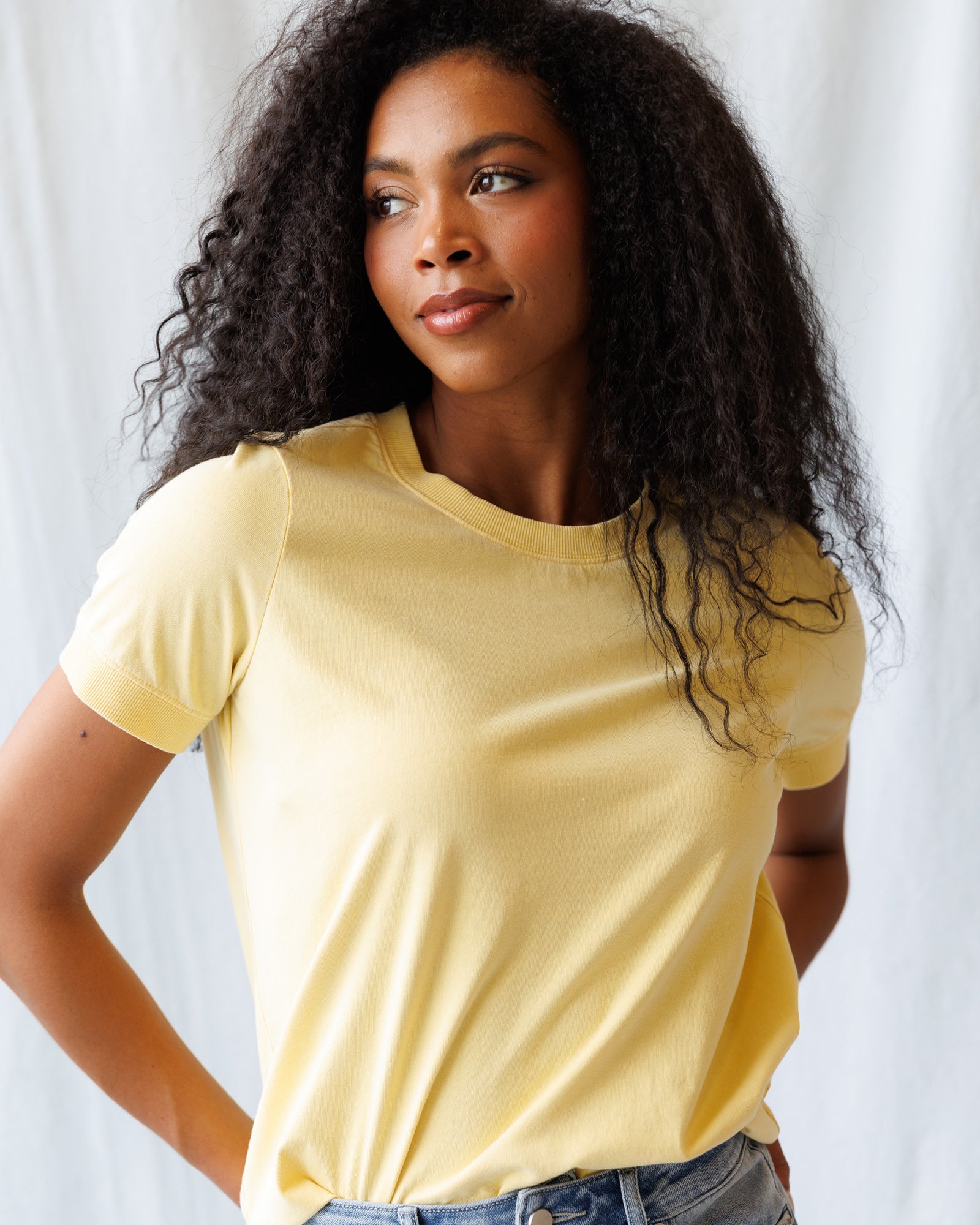 Woman wearing a yellow t-shirt against a white background