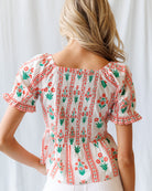 Woman wearing a floral blouse with a plain background