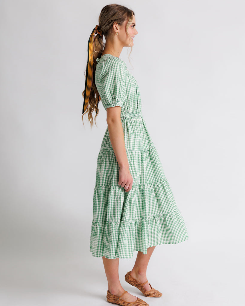 Model wearing a green gingham short sleeve, square neck midi dress.