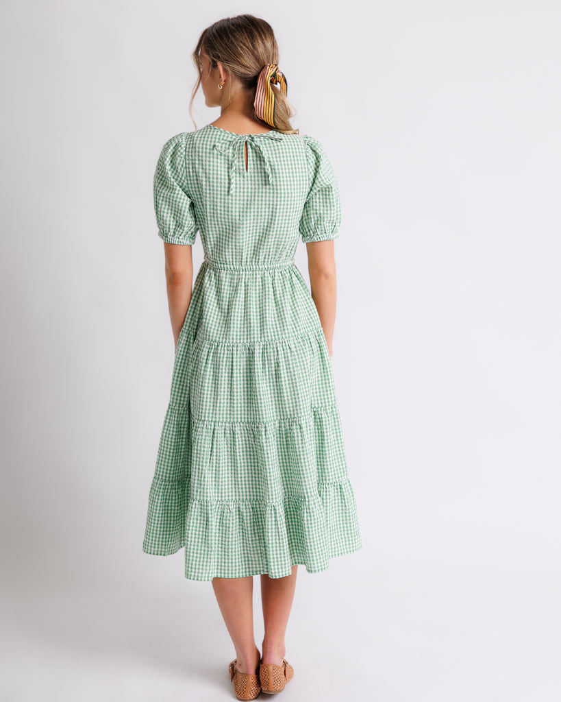 Model wearing a green gingham short sleeve, square neck midi dress.