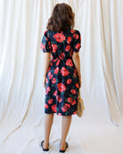 Woman wearing a floral dress with a plain background