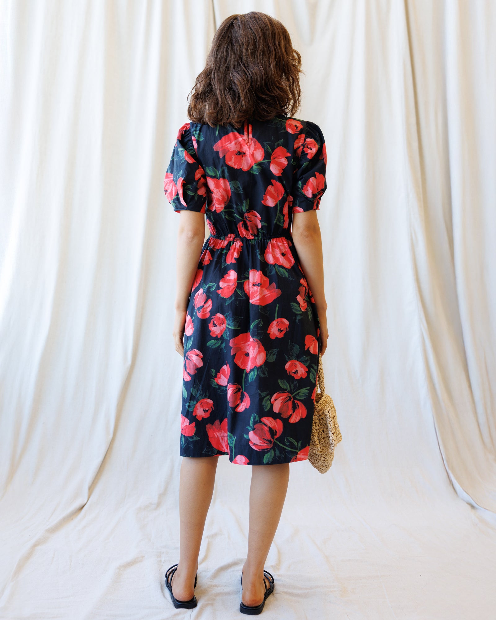 Woman wearing a floral dress with a plain background